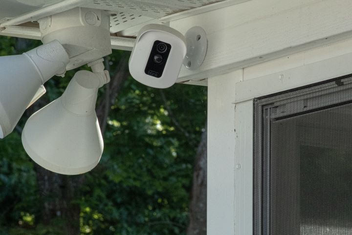 a house porch with a security camera and security lights attached to the roof